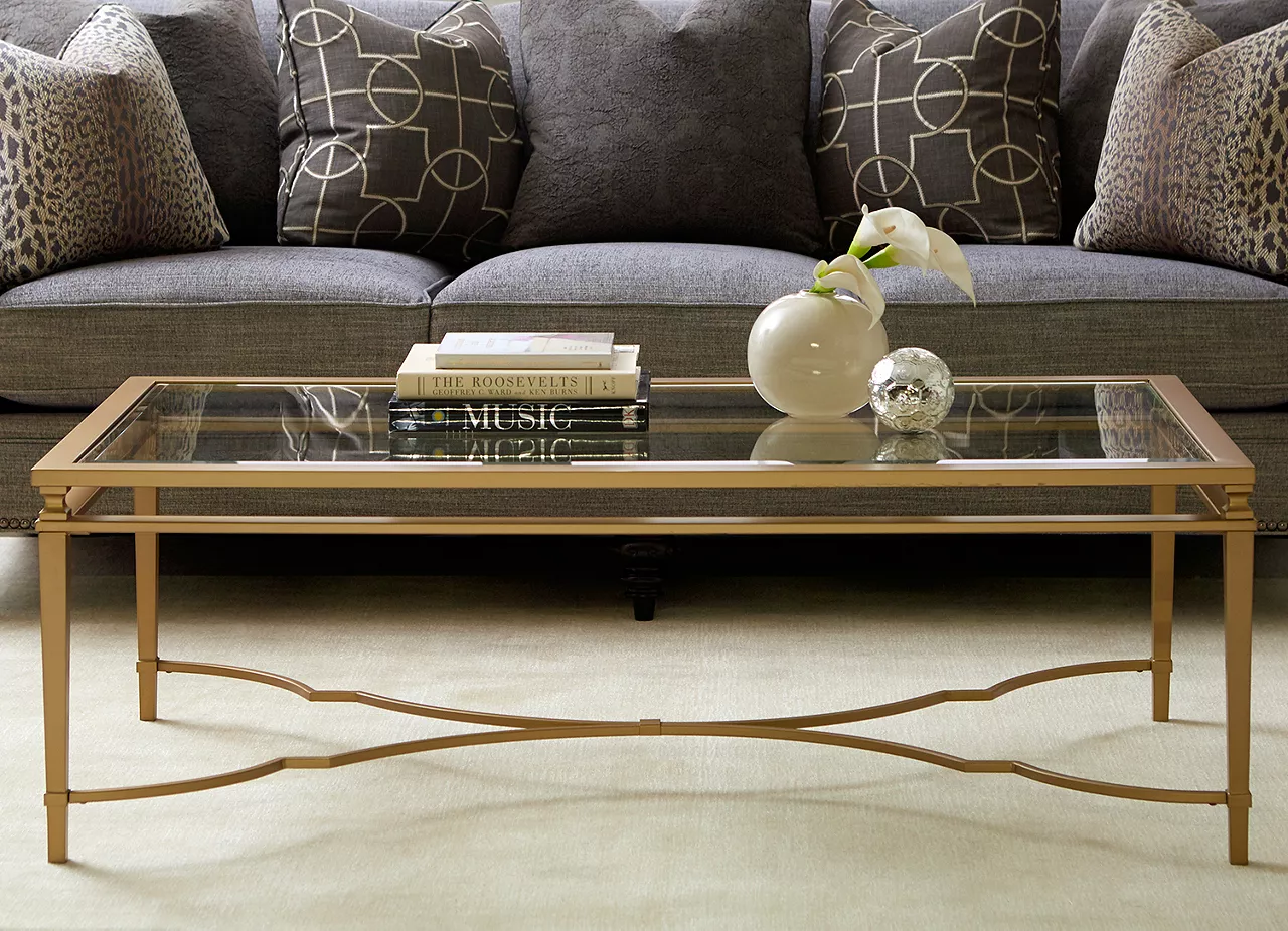 The Amani glass and gold finish coffee table in room scene.